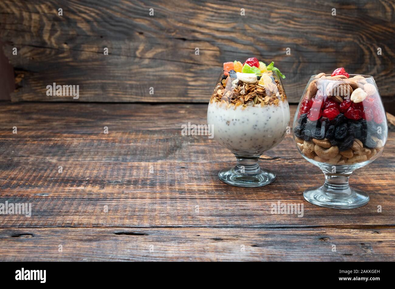 Bicchieri con frutta e noci. Frutta secca e frutti di bosco. Frutta secca. Una miscela di noci e semi. Foto Stock