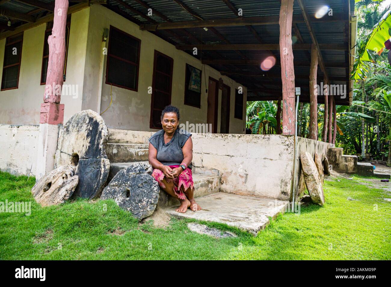 Yap Island, Stati Federati di Micronesia - Aug 04 2015: Locale micronesiano donne indigene seduto sul portico di una autentica casa locale lungo il banco di tre ston Foto Stock