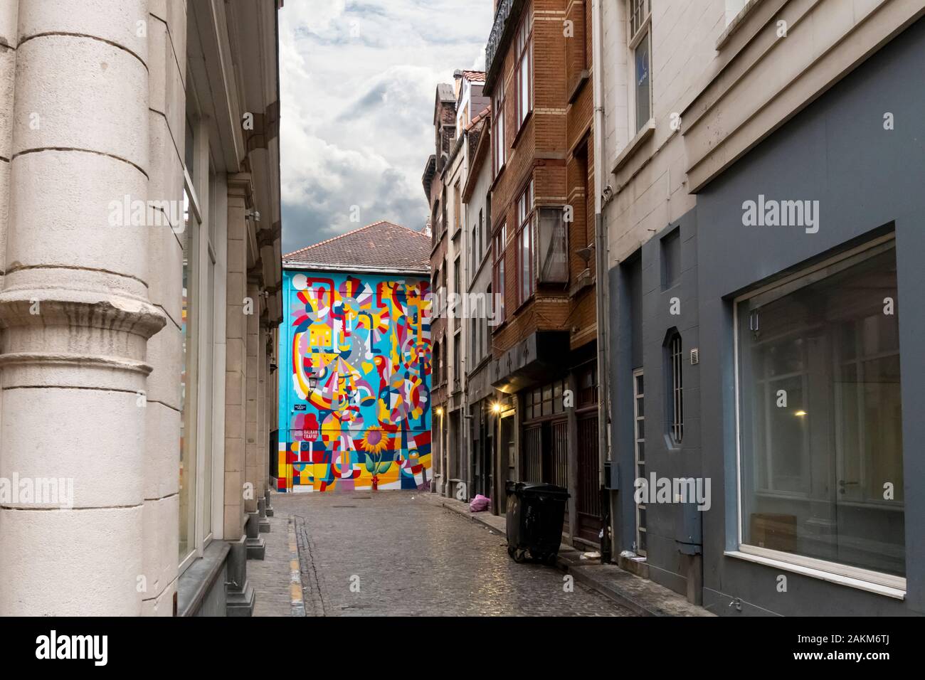 Una parete dipinta di colore di Rikardo Druškić alla fine di un vicolo di strada in una giornata piovosa nel centro storico di Bruxelles, Belgio. Foto Stock