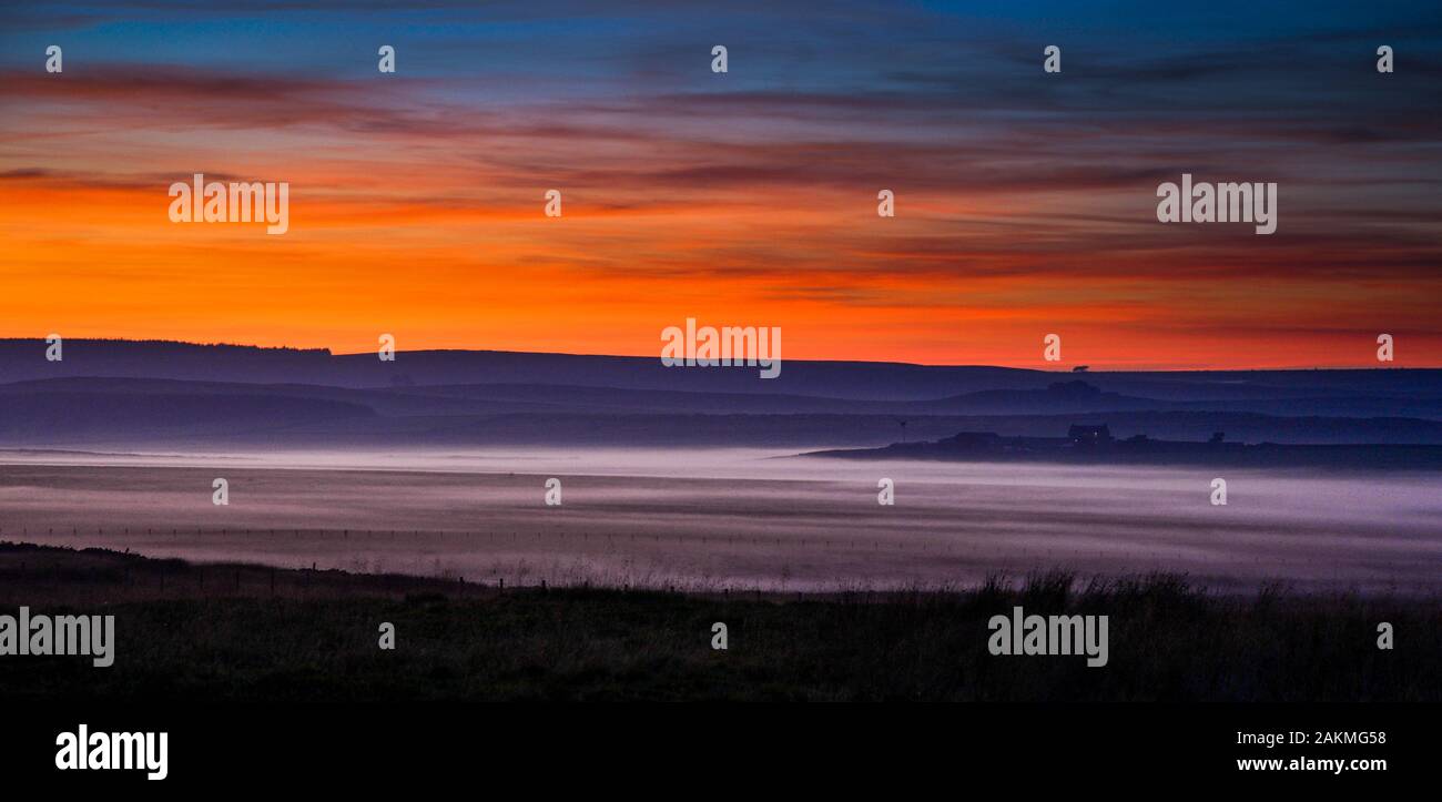 Guardando ad ovest accanto al generale Wade's strada militare (B6318) che costeggia il Vallum del muro romano in Northumberland Foto Stock