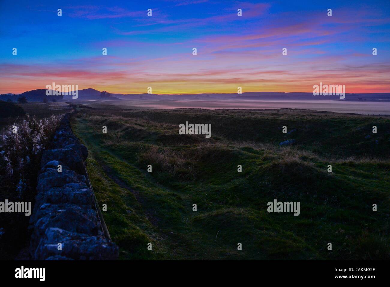 Guardando ad ovest accanto al generale Wade's strada militare (B6318) che costeggia il Vallum del muro romano in Northumberland Foto Stock