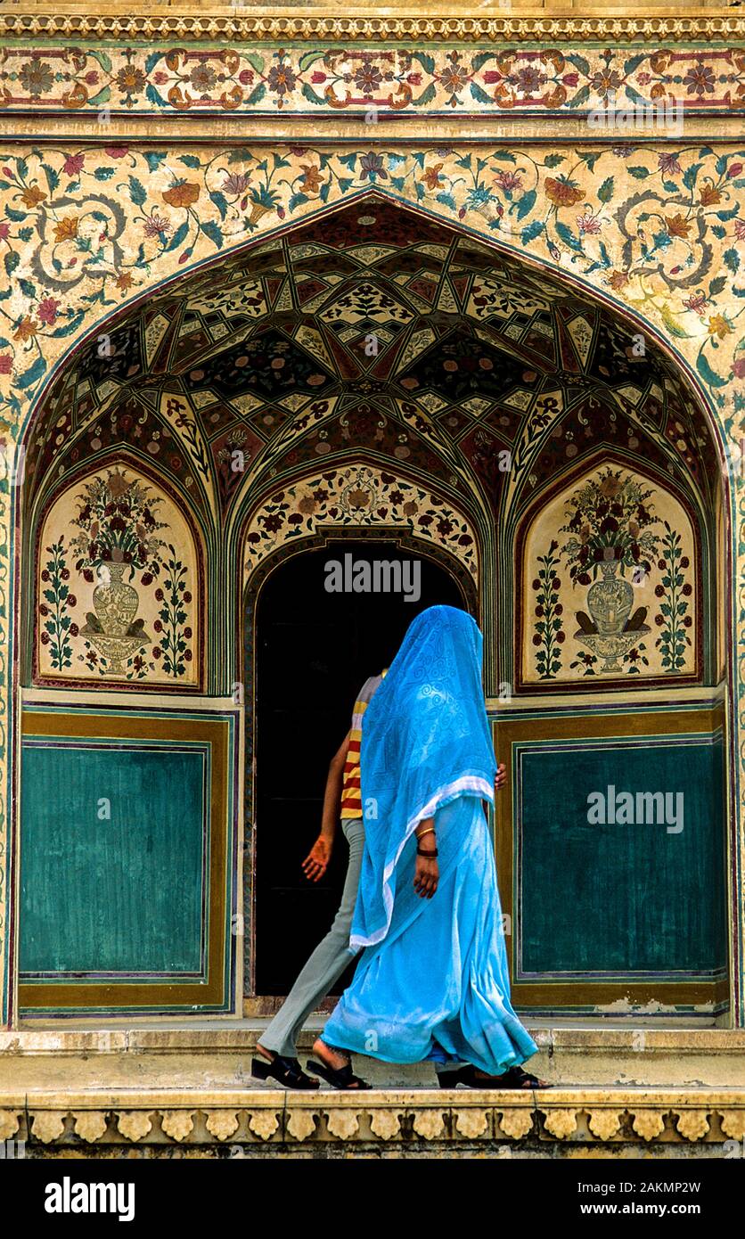 La donna in un blue saree e sua figlia moderno a piedi nella parte anteriore di una porta al Forte Amber in Amer, Rajasthan, India Foto Stock