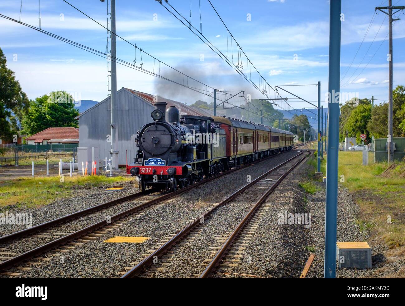 La storica Baldwin 5917 Picnic treno a vapore a pieno vapore che passa attraverso una stazione di Albion Park, NSW, Australia Foto Stock