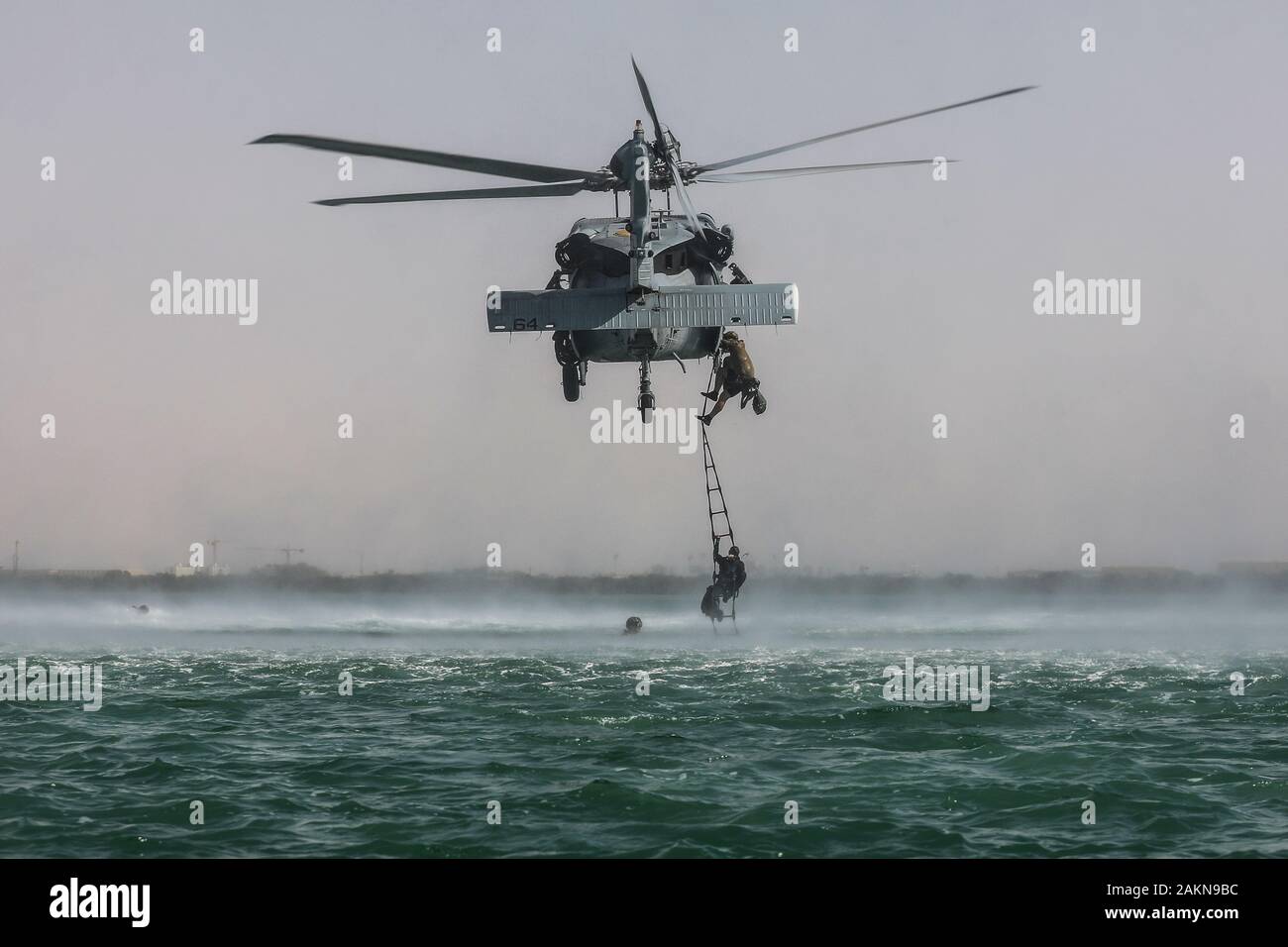 Soldati con la quinta delle forze speciali Gruppo (Airborne) utilizzano una corda a queste ultime di salire fino a U.S. Navy MH-60S Seahawk, Helocast durante la formazione. Helocasting è una tecnica di volo utilizzato da forze per le operazioni speciali per inserire un distacco operativo alfa in una zona militare delle operazioni tramite l'acqua. (U.S. Foto dell'esercito da Staff Sgt. Justin Moeller, quinto SFG(A) Affari pubblici) Foto Stock