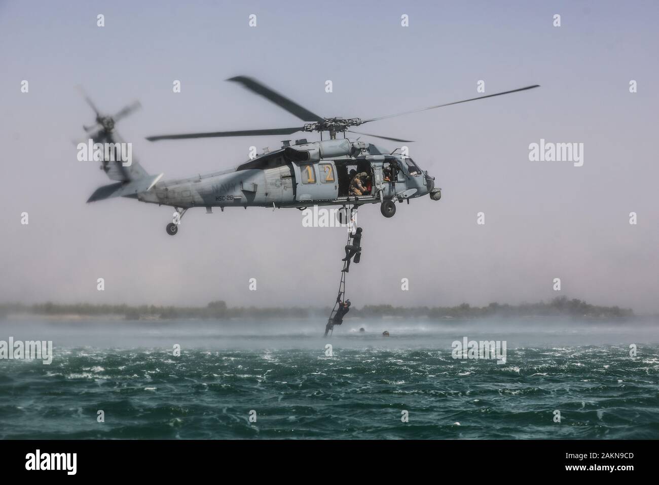 Soldati con la quinta delle forze speciali Gruppo (Airborne) utilizzano una corda a queste ultime di salire fino a U.S. Navy MH-60S Seahawk, Helocast durante la formazione. Helocasting è una tecnica di volo utilizzato da forze per le operazioni speciali per inserire un distacco operativo alfa in una zona militare delle operazioni tramite l'acqua. (U.S. Foto dell'esercito da Staff Sgt. Justin Moeller, quinto SFG(A) Affari pubblici) Foto Stock