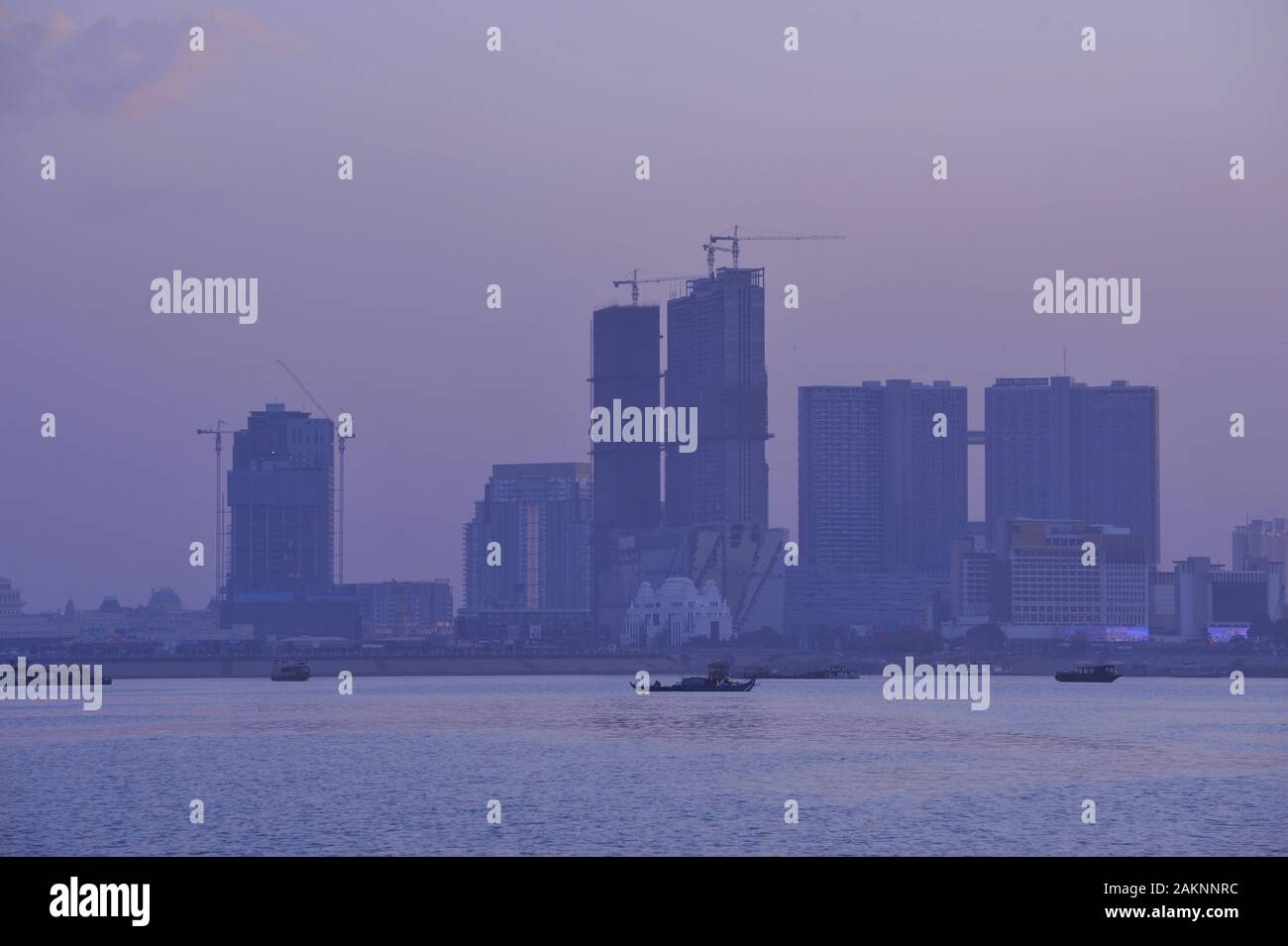 Inquinamento, smog e polvere, Isola dei Diamanti (Koh Pich) al tramonto, grattacieli in costruzione, Phnom Penh, Cambogia, Indochina. © Kraig Lieb Foto Stock