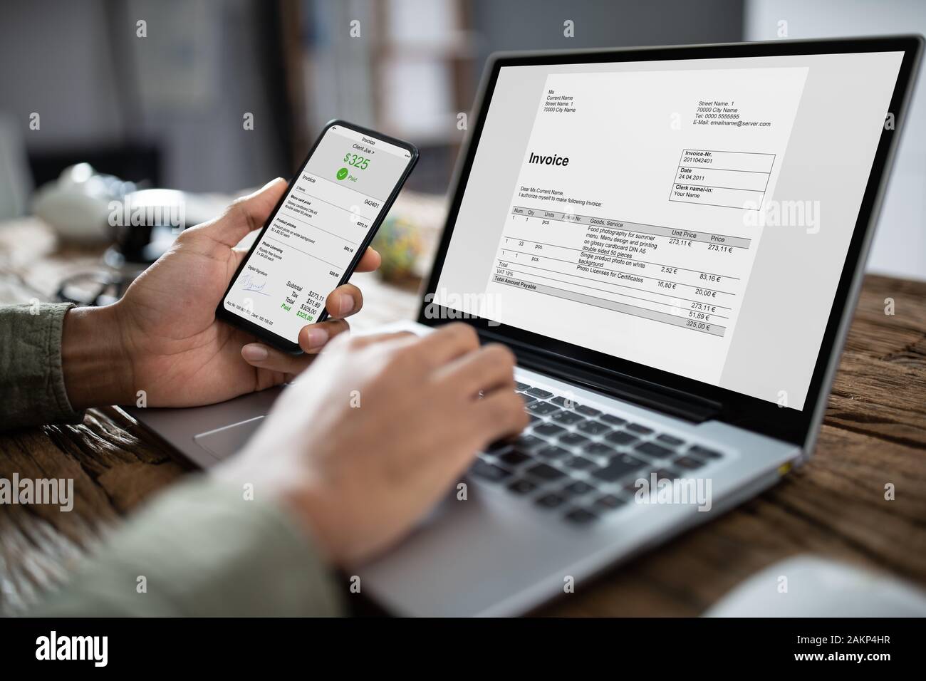 Close-up di imprenditore il mani lavorando su fattura su computer portatile in ufficio Foto Stock