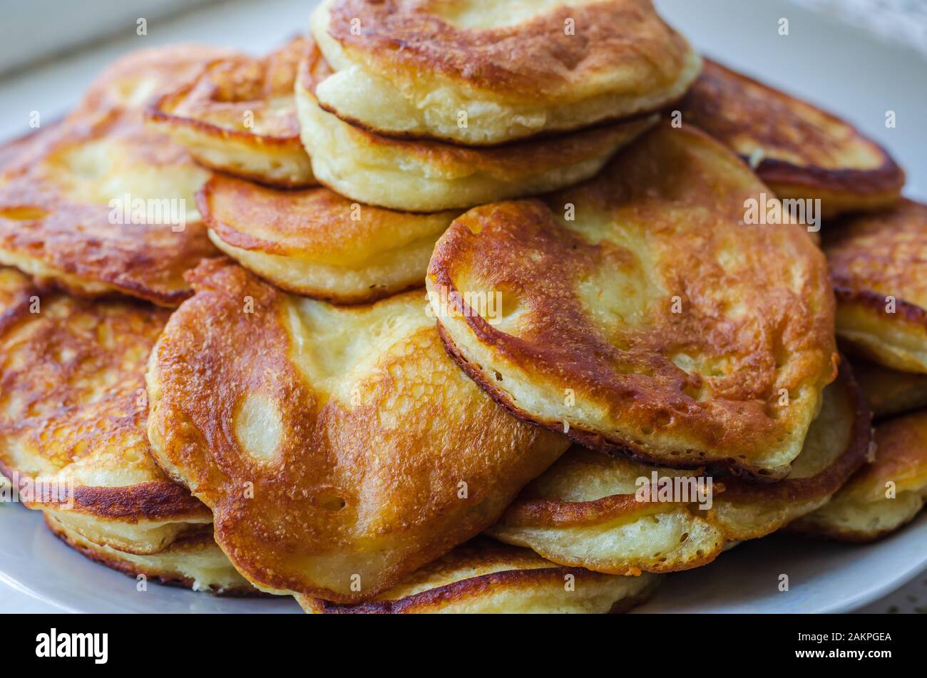 Tradizionali ucraine di frittelle. Un sacco di magnifiche deliziose frittelle fritte su una piastra. Close-up. Messa a fuoco selettiva. Cucina tradizionale. Foto Stock