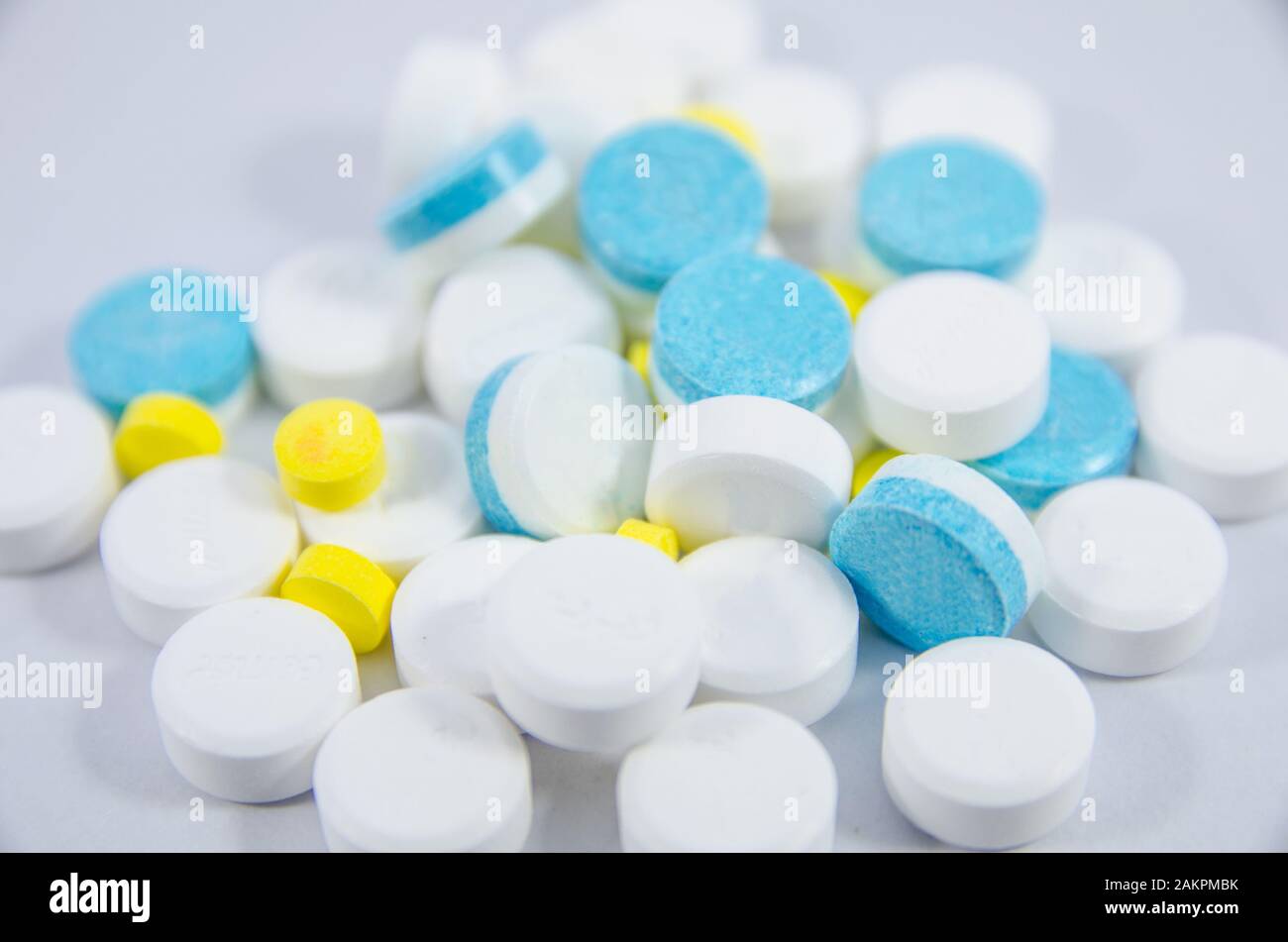 pillola bianca, blu e gialla su terreno nero bianco Foto Stock