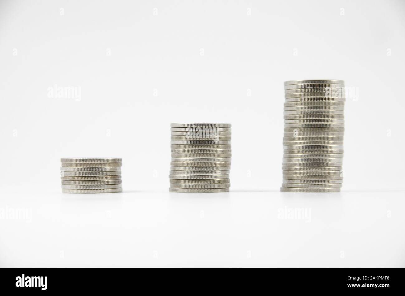 tre pile di monete tailandesi su sfondo bianco Foto Stock