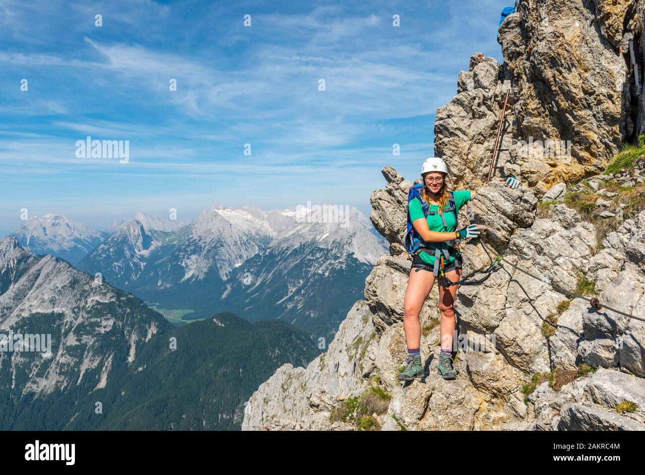 Alpinista, giovane donna con arrampicata attrezzature in piedi su una roccia, fissato via ferrata, Mittenwald via ferrata, montagne Karwendel, Mittenwald Foto Stock