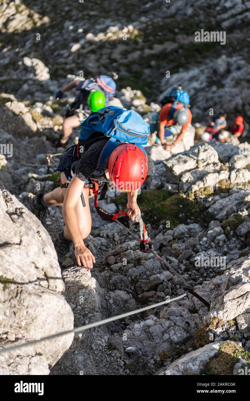 Un gruppo di alpinisti con casco su un assicurato via ferrata, Mittenwald via ferrata, montagne Karwendel, Mittenwald, Germania Foto Stock