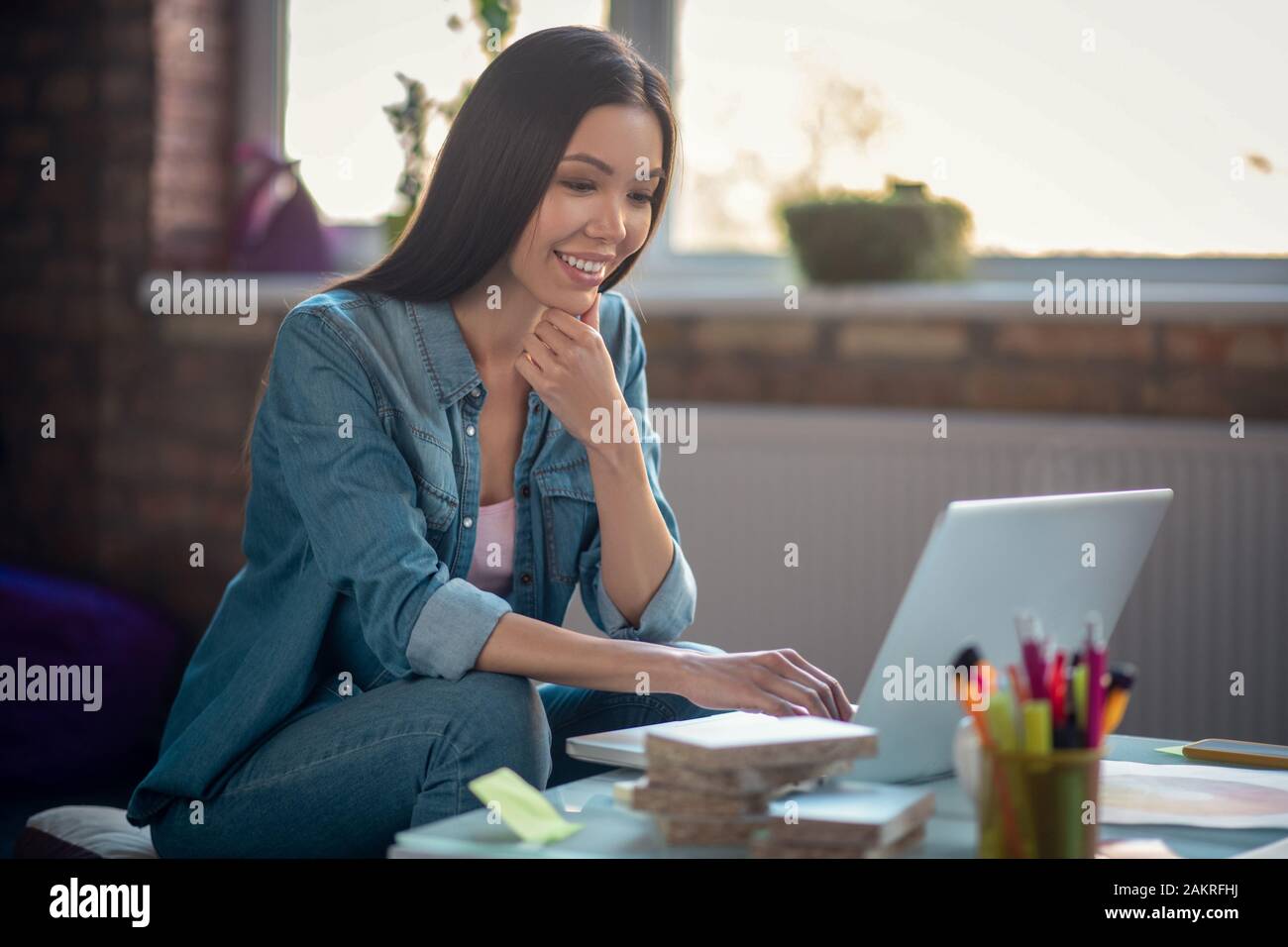 Positivo donna asiatica a lavorare al suo progetto Foto Stock
