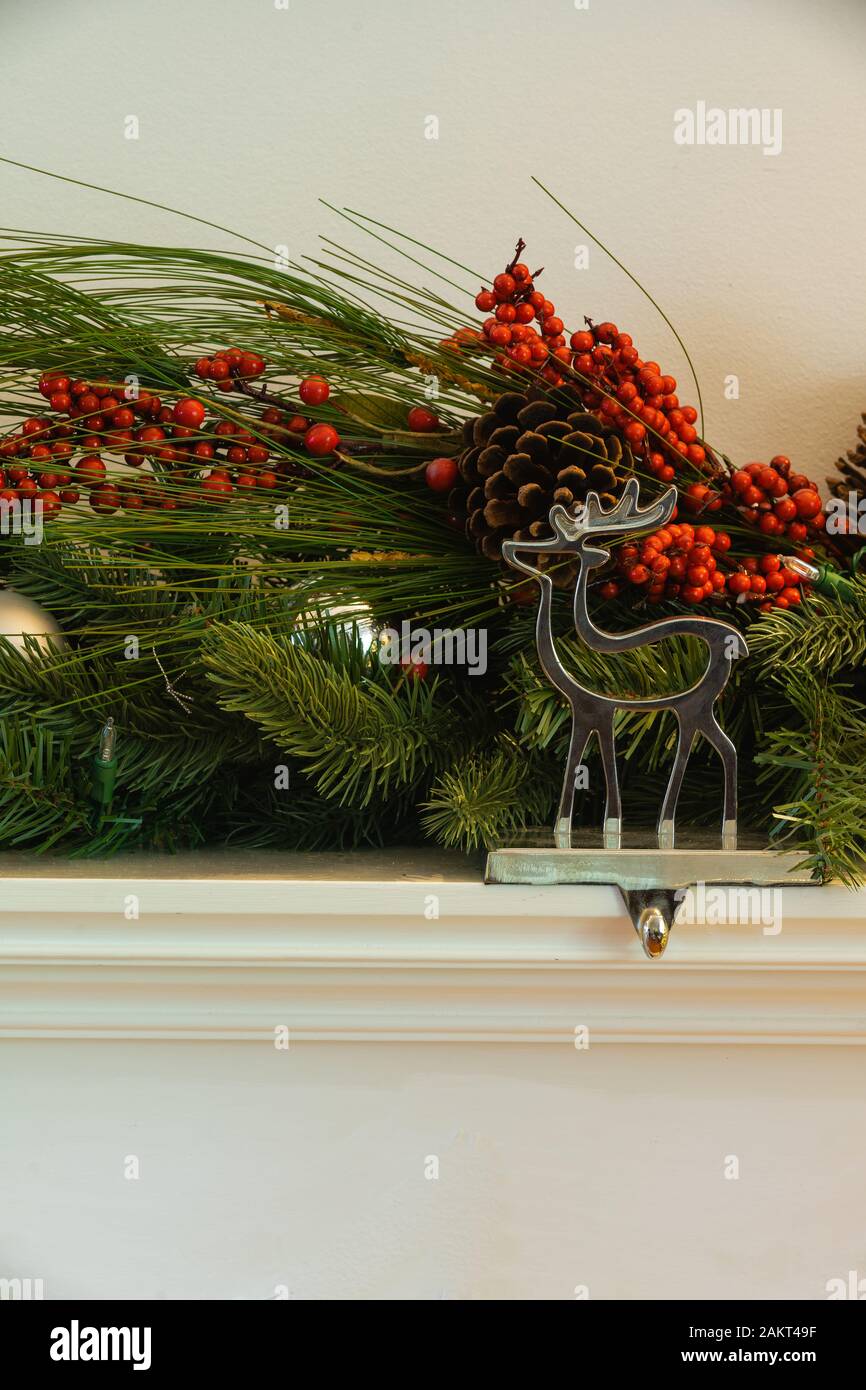 Camino di Natale renne appendiabiti con garland verde ciliegia e palle di bauballs verticale Foto Stock