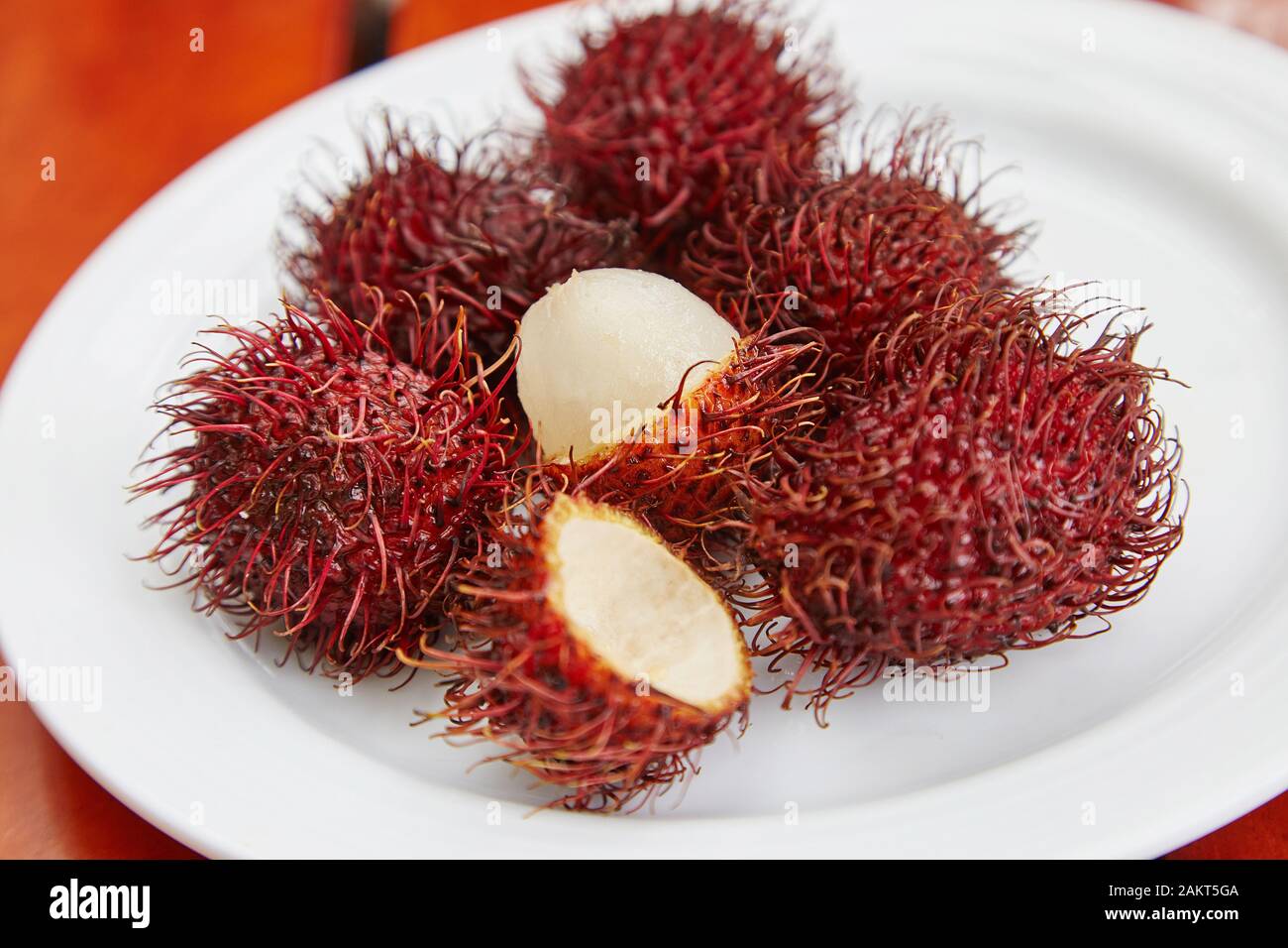 Un piatto di Rambutans, un frutto rosso spiky. Foto Stock