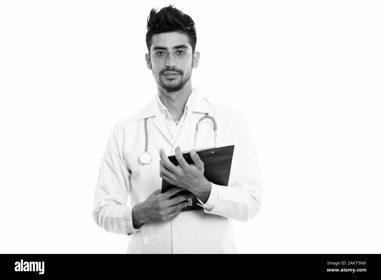 Studio shot del giovane uomo persiano medico tenendo negli appunti Foto Stock