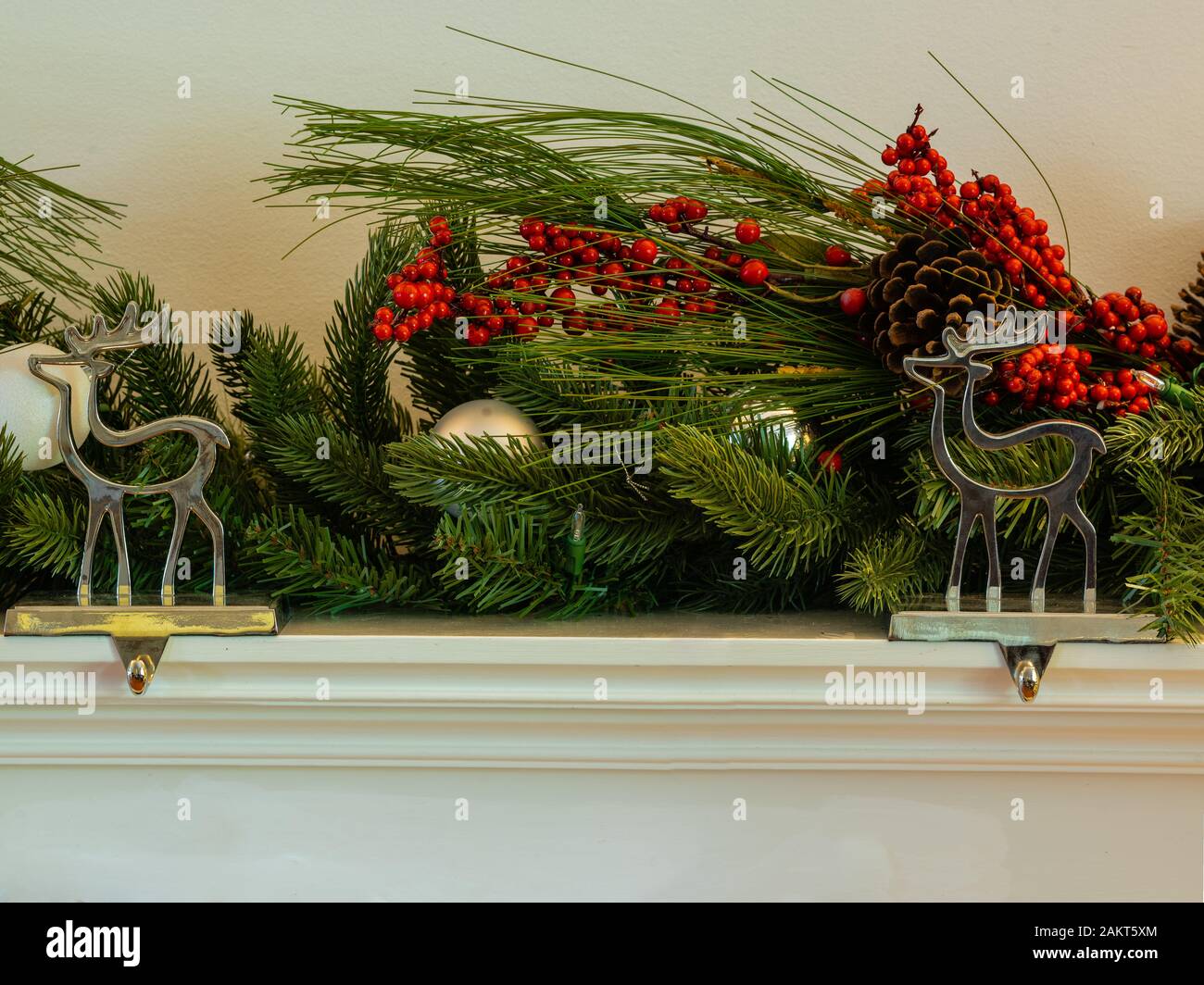 Camino di natale renne appendino con green garland ciliegia e bauballs panorama Foto Stock