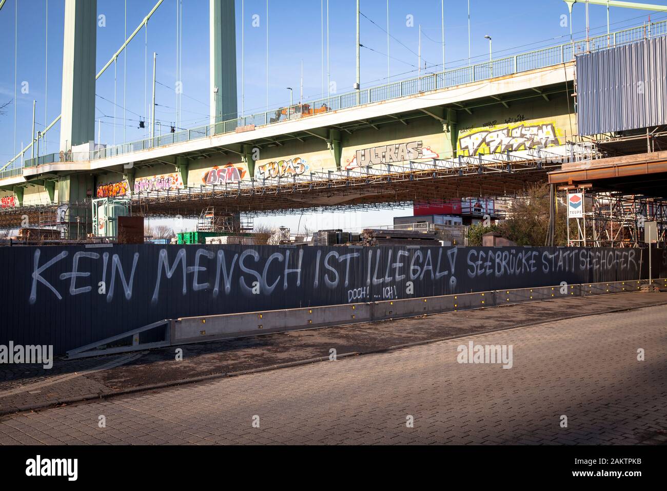 La protesta contro la politica dei rifugiati del Segretario degli Interni Horst Seehofer in un recinto di costruzione al di sotto del ponte Muelheimer, Colonia, Germania. Foto Stock
