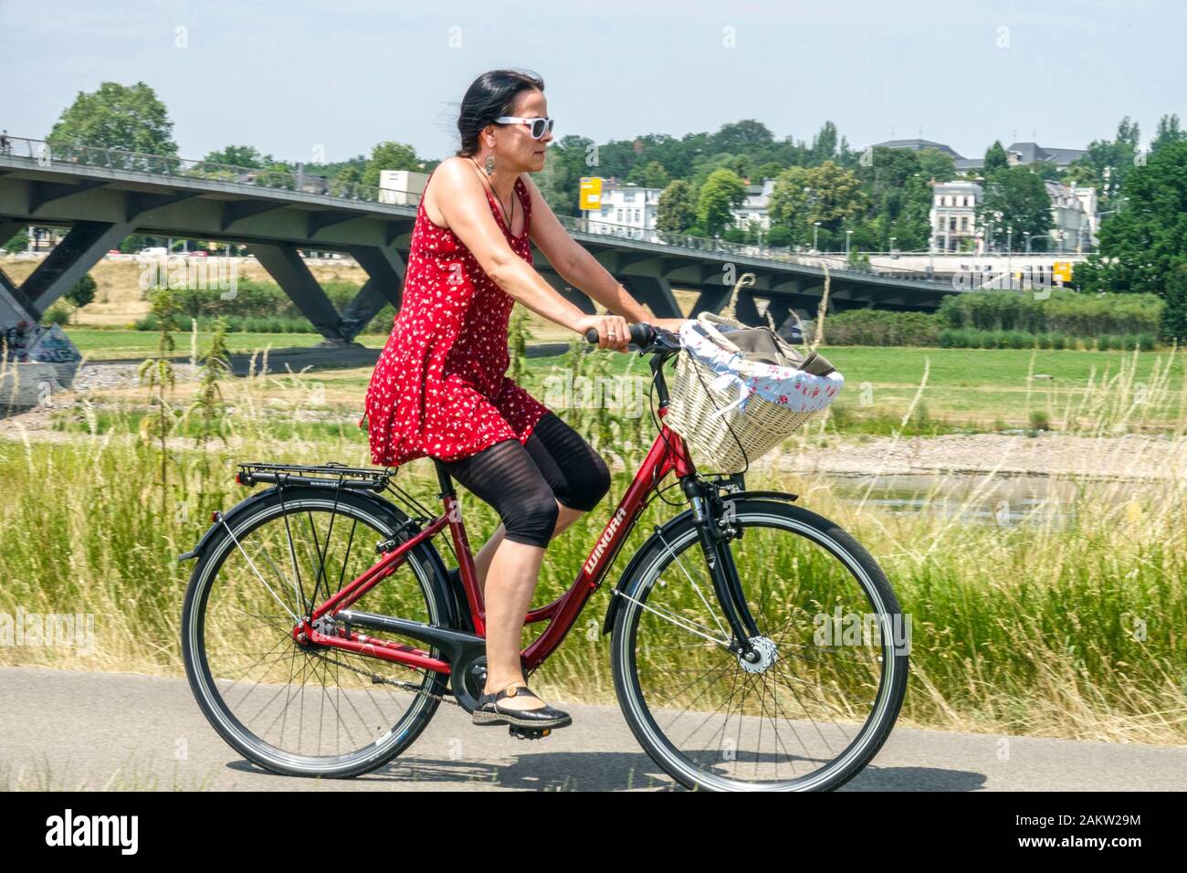 Donna matura cavalcare una bicicletta lungo il fiume Elba Dresden Germania stile di vita Foto Stock