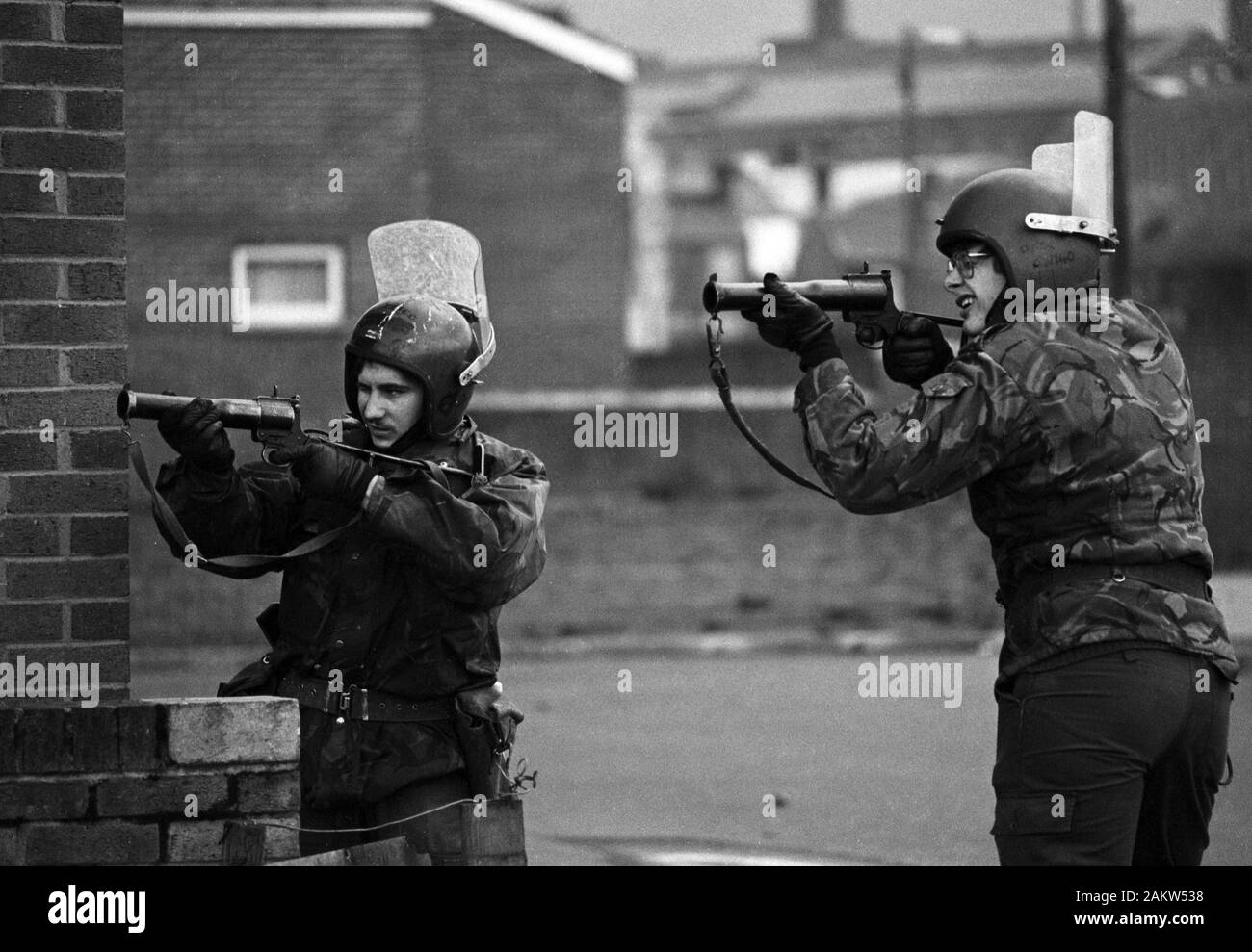 Le truppe con le loro armi al pronto tenere d'occhio la pietra gettando giovani in Falls Road, Belfast. Foto Stock