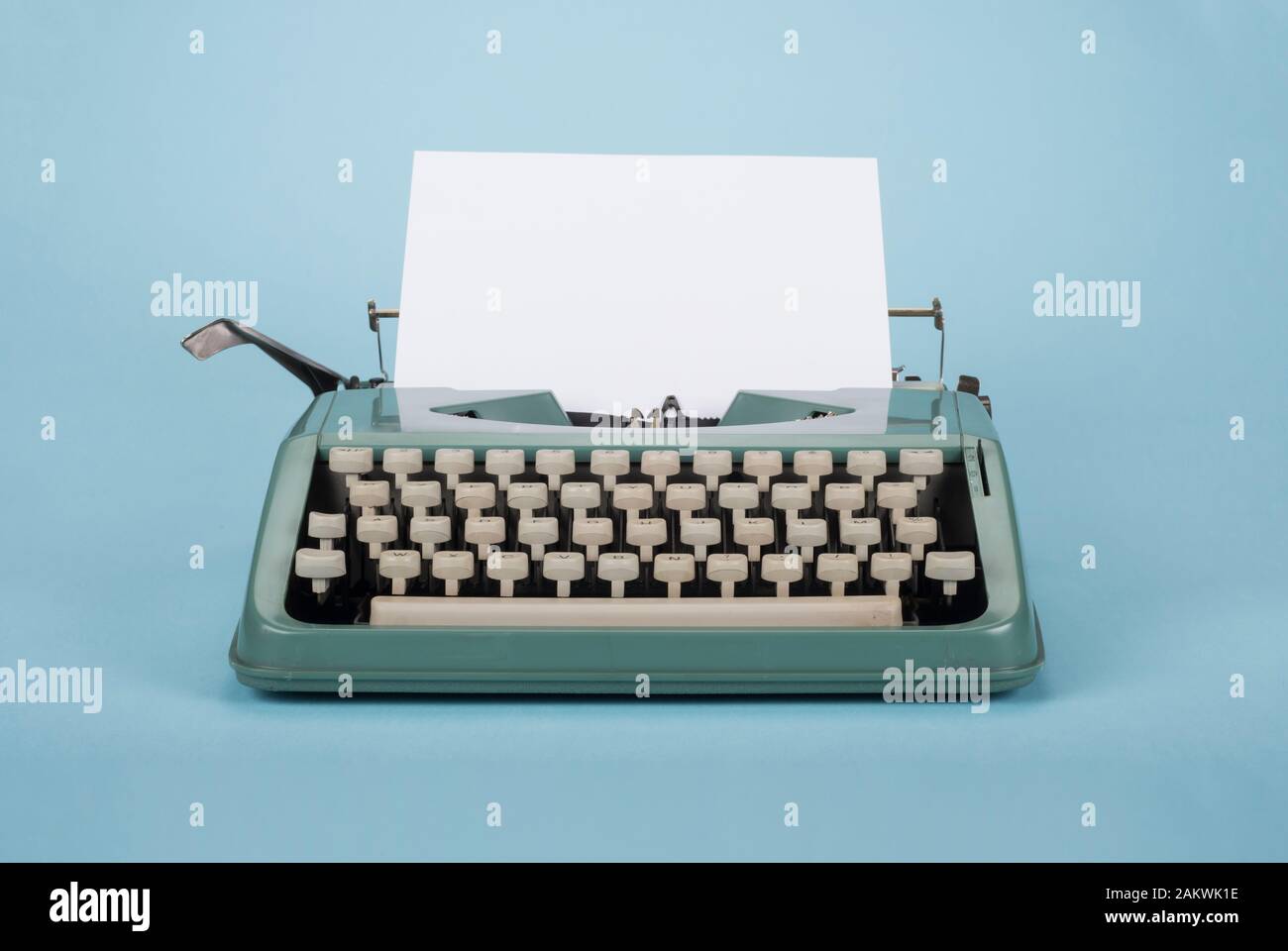 Vecchia macchina da scrivere retro con carta su sfondo azzurro Foto Stock