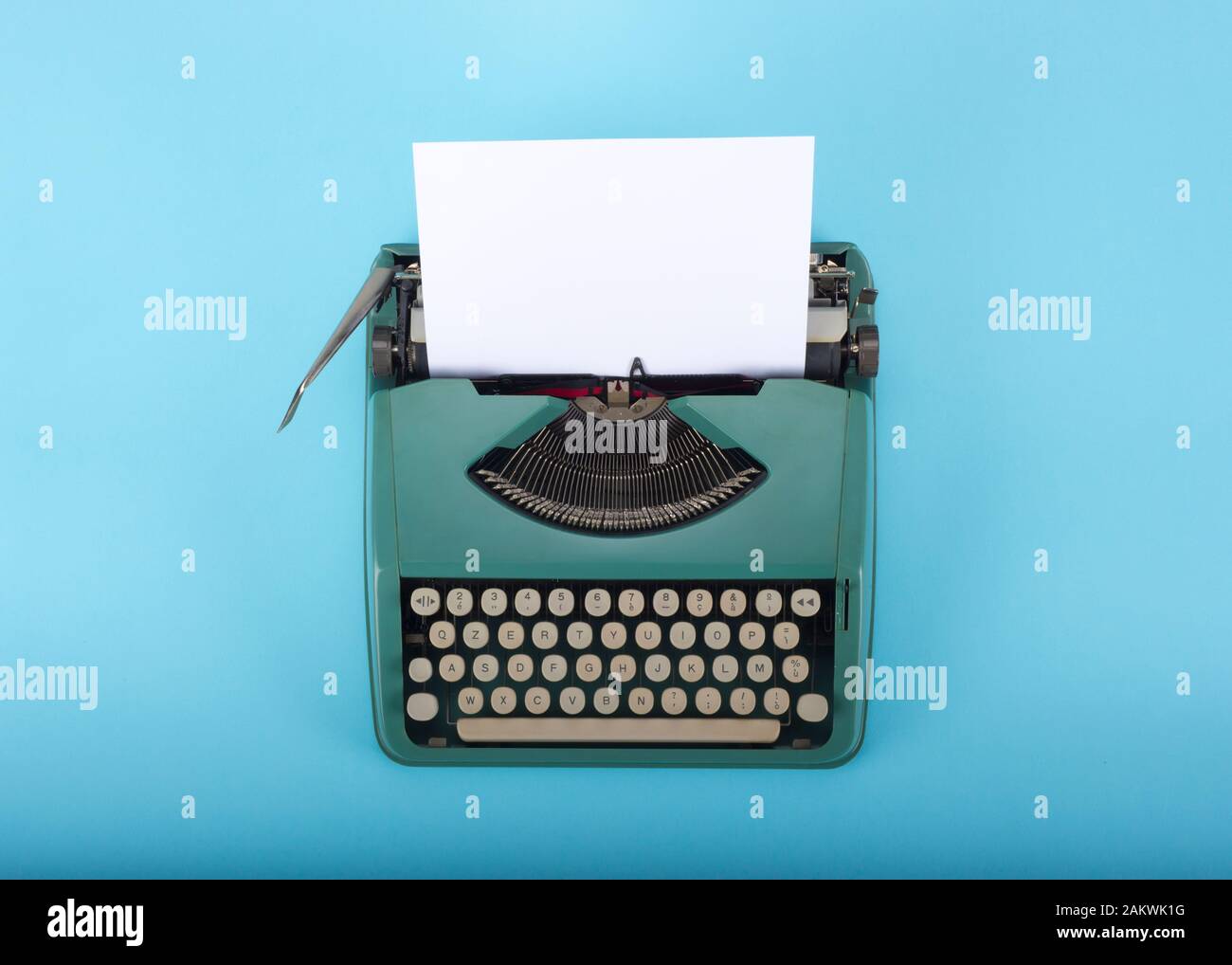 Vecchia macchina da scrivere retro con carta su sfondo azzurro Foto Stock