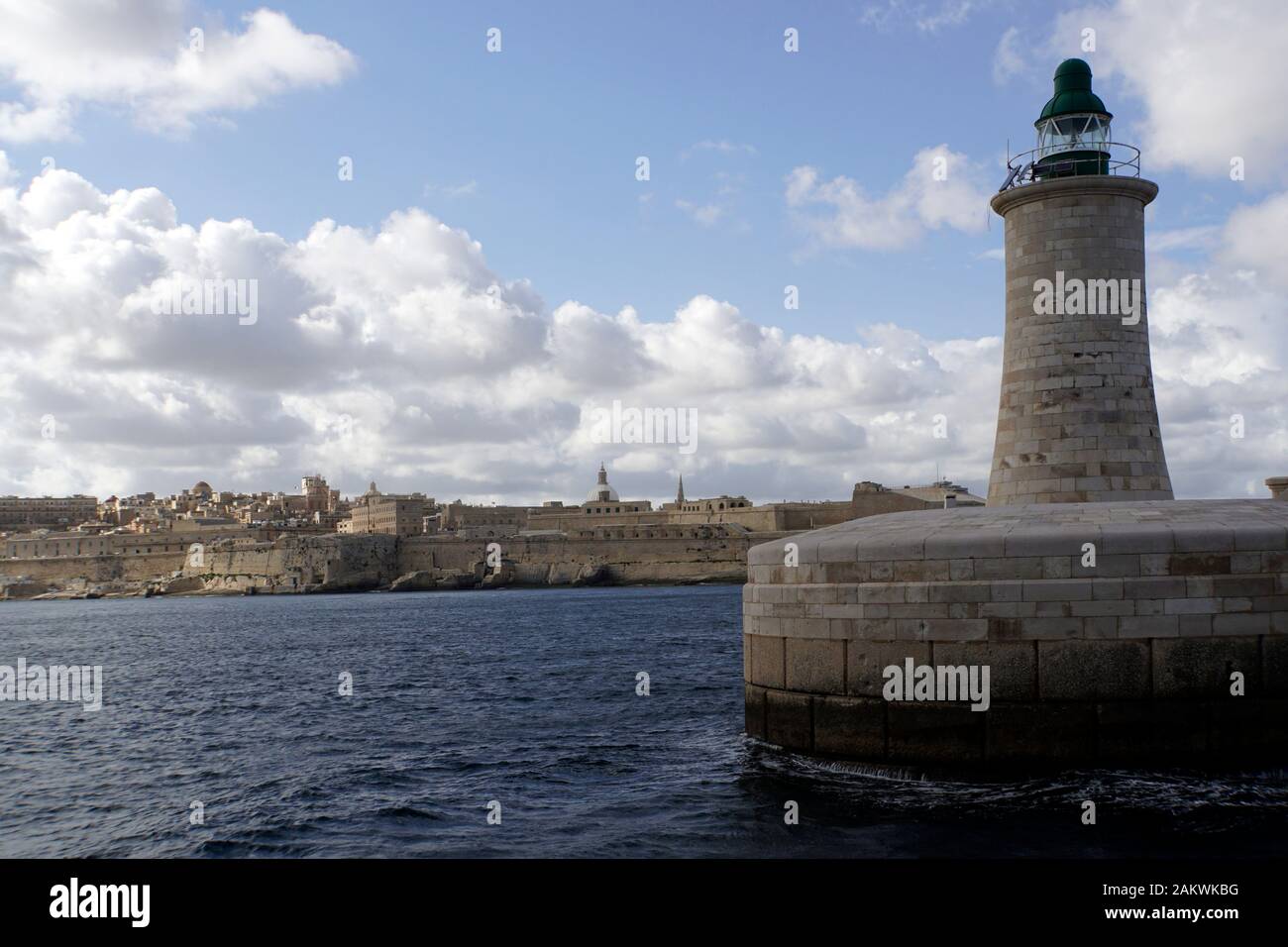 Hafendrundfahrt durch den Grand Harbour - Leuchtturm an der Hafeneinfahrt, im Hintergrund Valletta, Malta Foto Stock