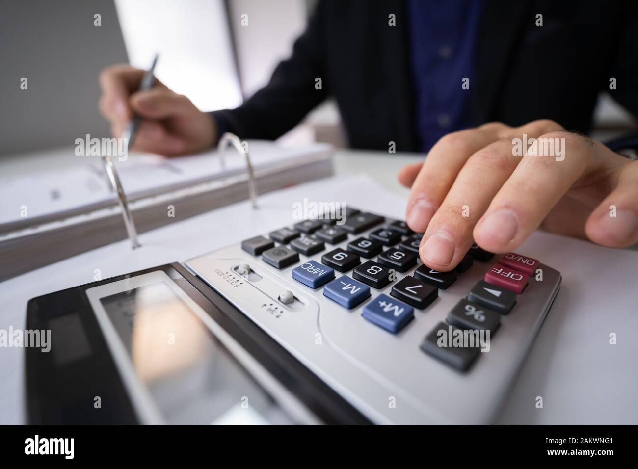 Sezione mediana di imprenditore il calcolo fiscale alla scrivania in ufficio Foto Stock