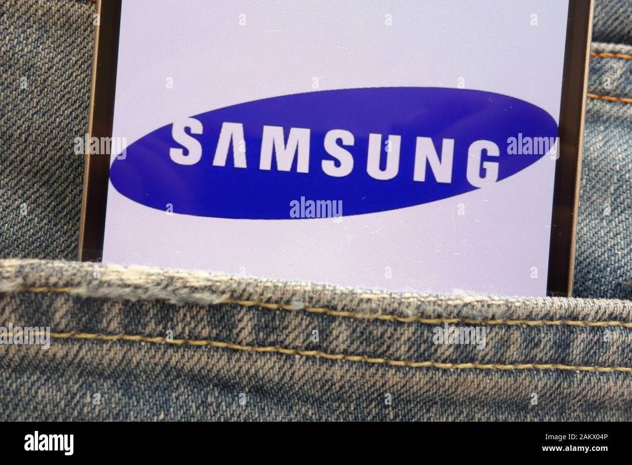 Samsung logo visualizzato sullo smartphone nascosto nella tasca dei jeans Foto Stock
