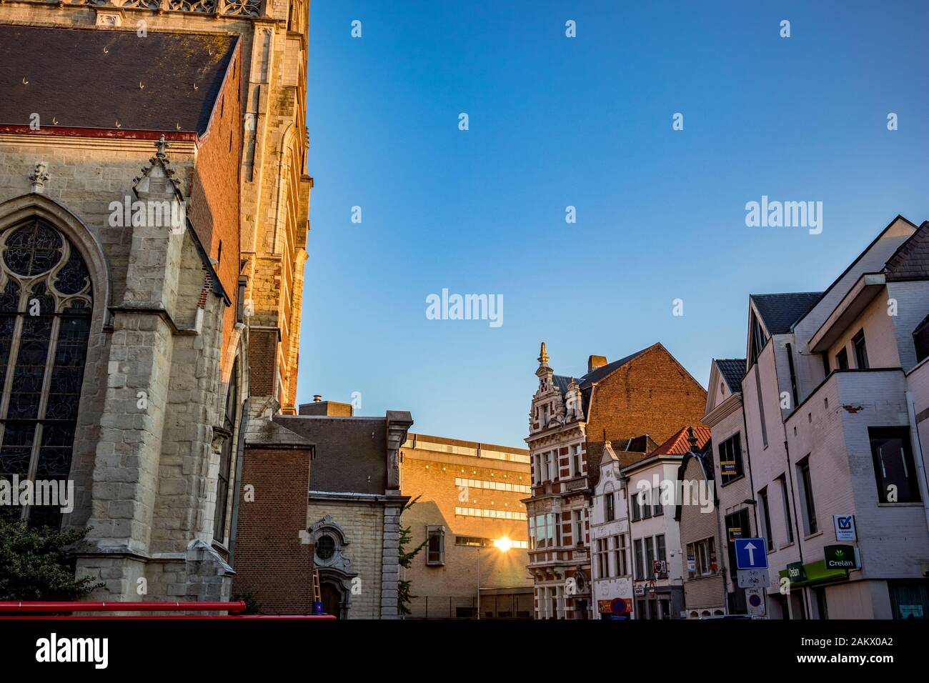 Aalst, BELGIO - 29 AGOSTO 2019: Vista laterale, angolo illuminato dalla luce del sole della Collegiata Saint-Martin. Vista sulla strada, cielo blu chiaro, Golden hou Foto Stock