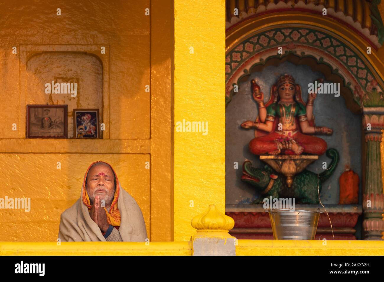 VARANASI, INDIA, 18 gennaio 2019 : un uomo indù è pregare la mattina presto da un edificio di fronte al fiume Gange. Foto Stock