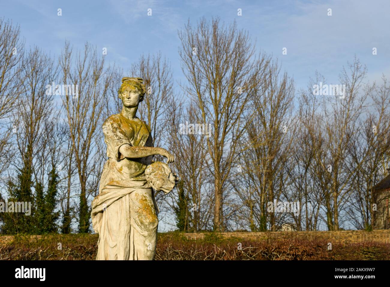 una scultura di una donna in un giardino europeo Foto Stock