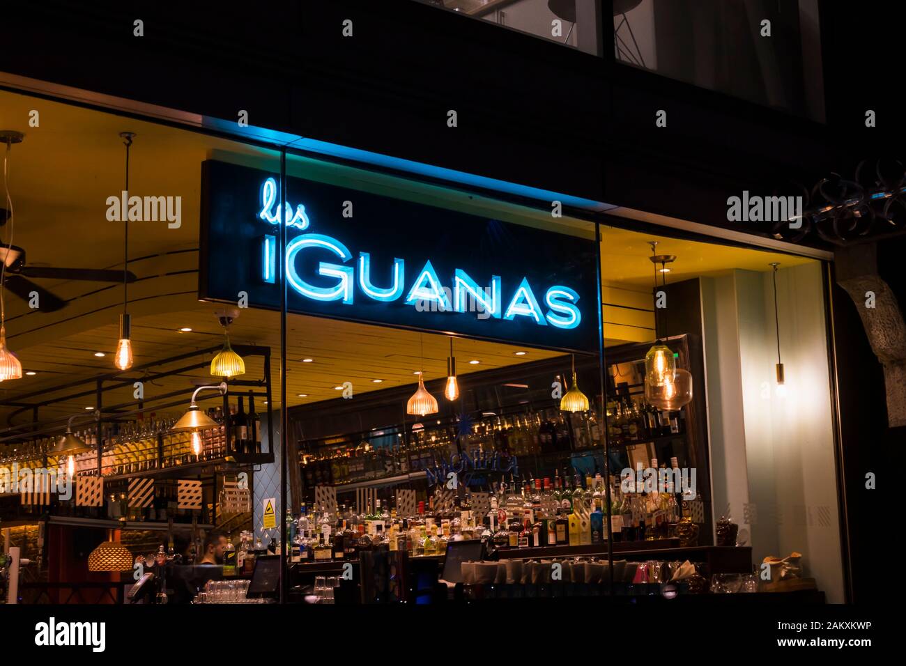 A tarda notte vista dall'esterno del bar chiuso all'interno di Las di iguana ristorante nel centro di Southbank, London SE1 con neon blu accesa nome sign Foto Stock