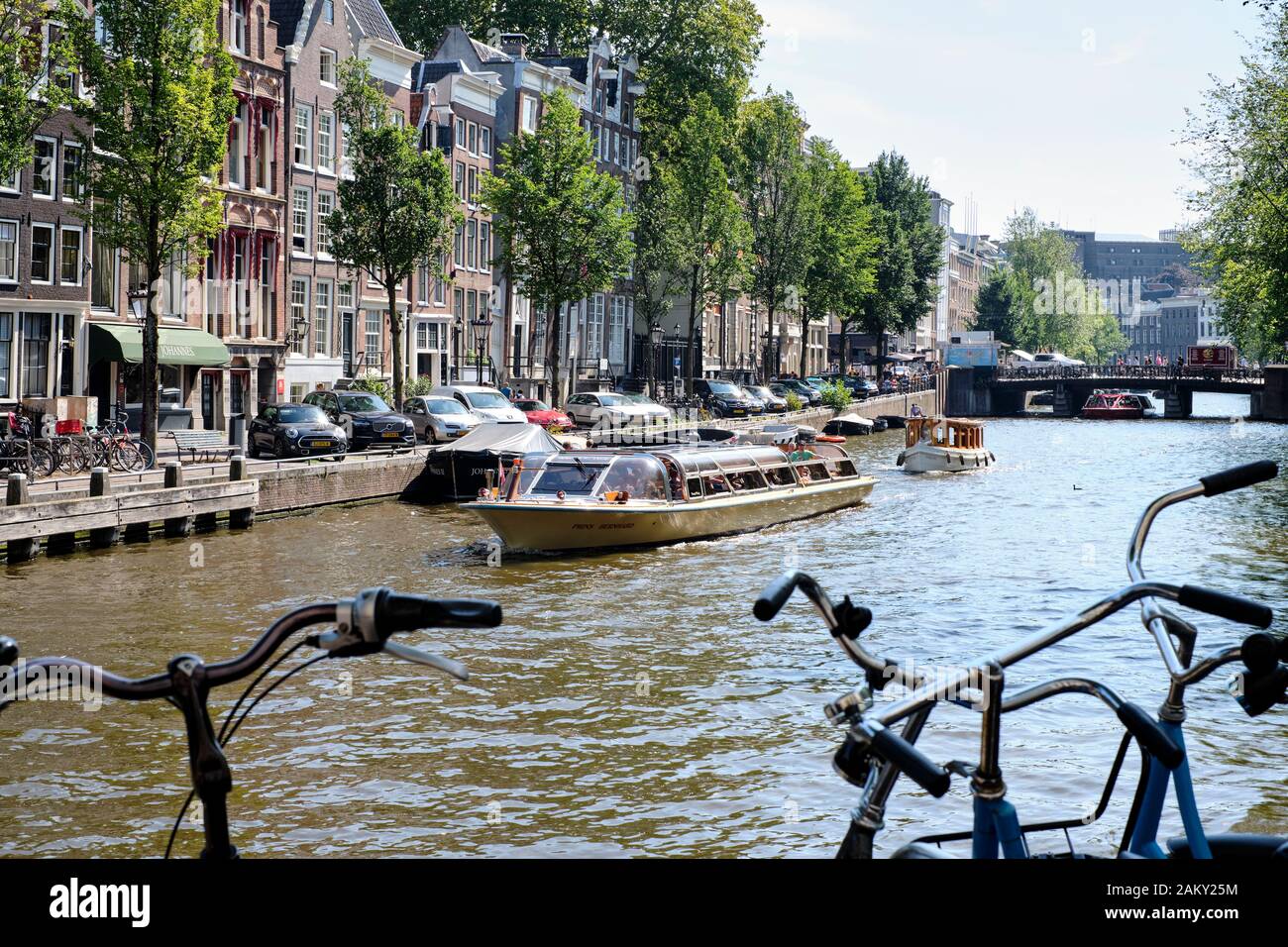 In estate le persone che si divertono con le loro barche nei canali di Amsterdam, Paesi Bassi. Foto Stock