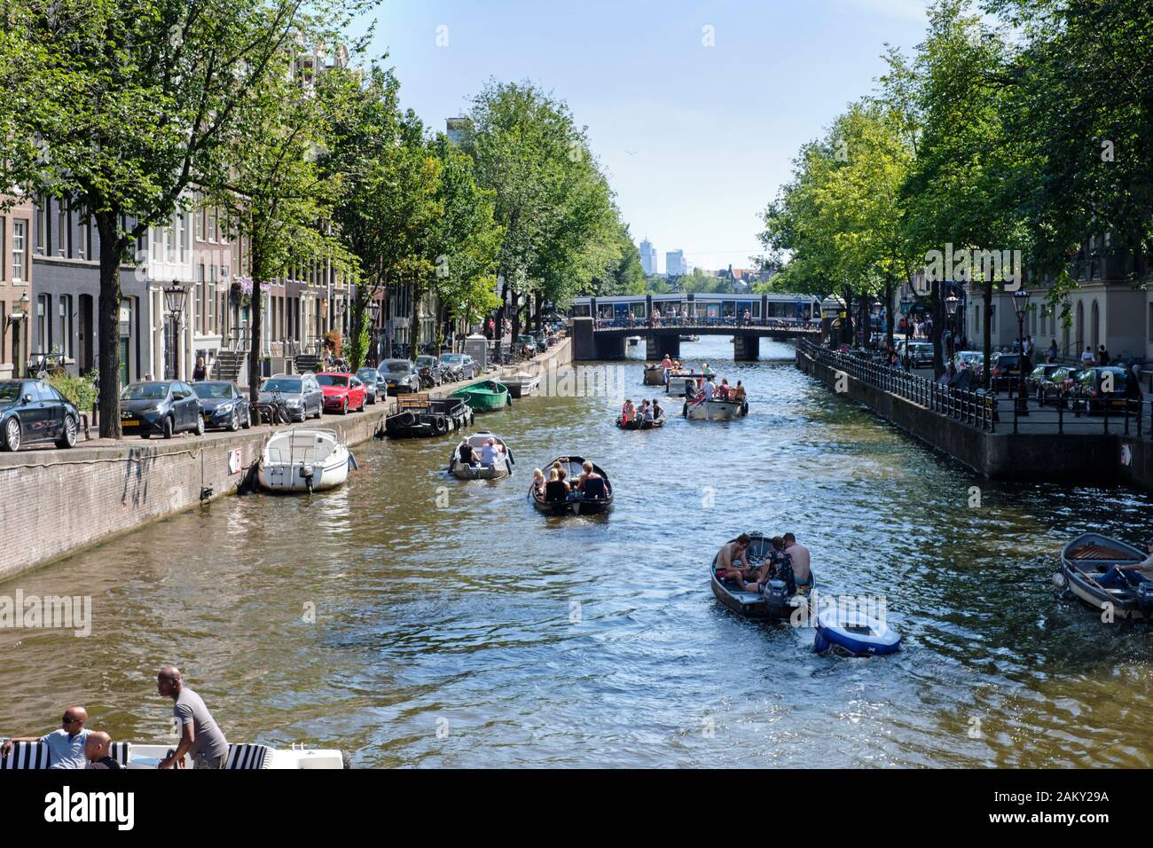 In estate le persone che si divertono con le loro barche nei canali di Amsterdam, Paesi Bassi. Foto Stock