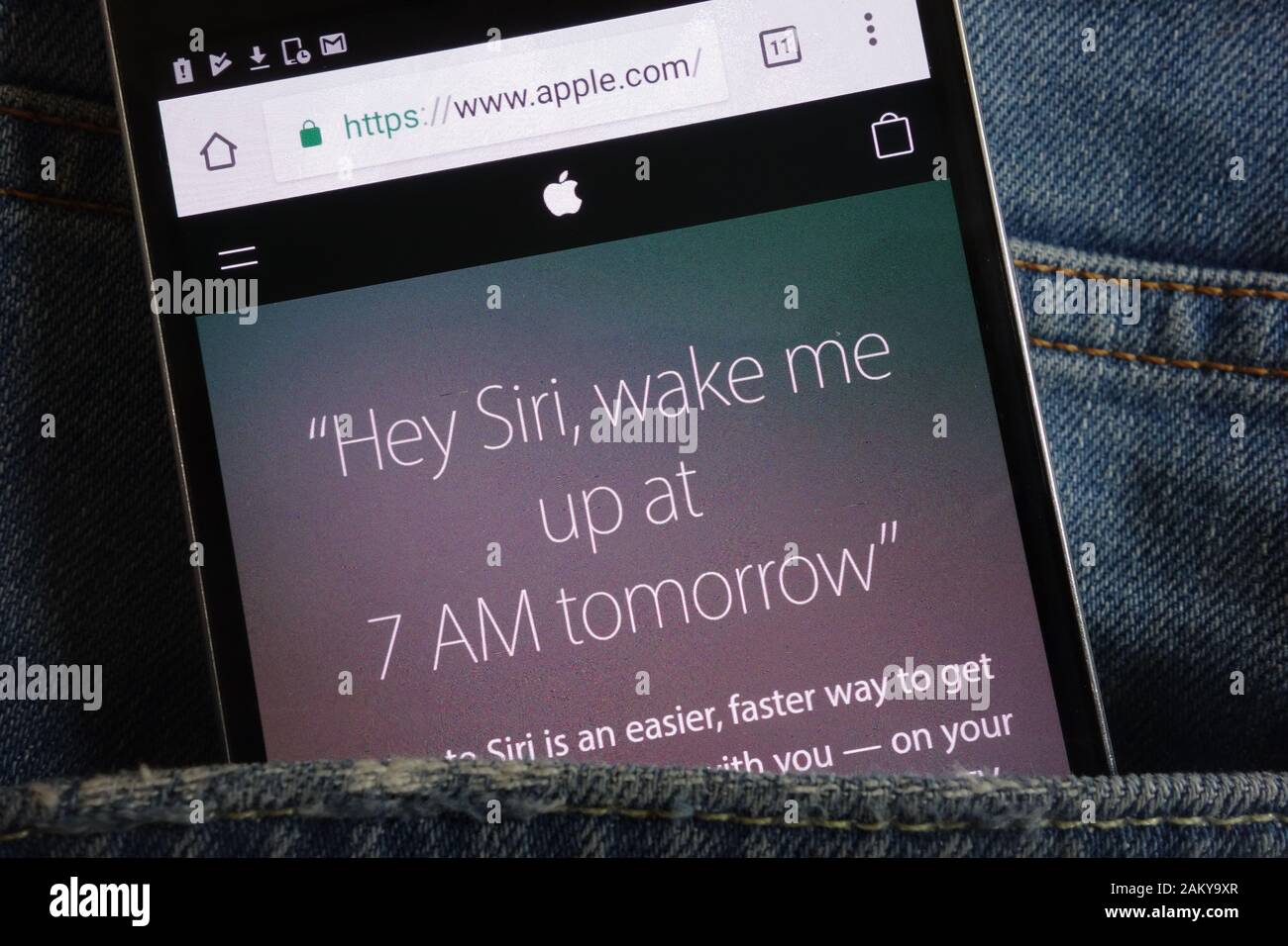 Testo su Siri sul sito web Apple visualizzato sullo smartphone nascosto in tasca jeans Foto Stock