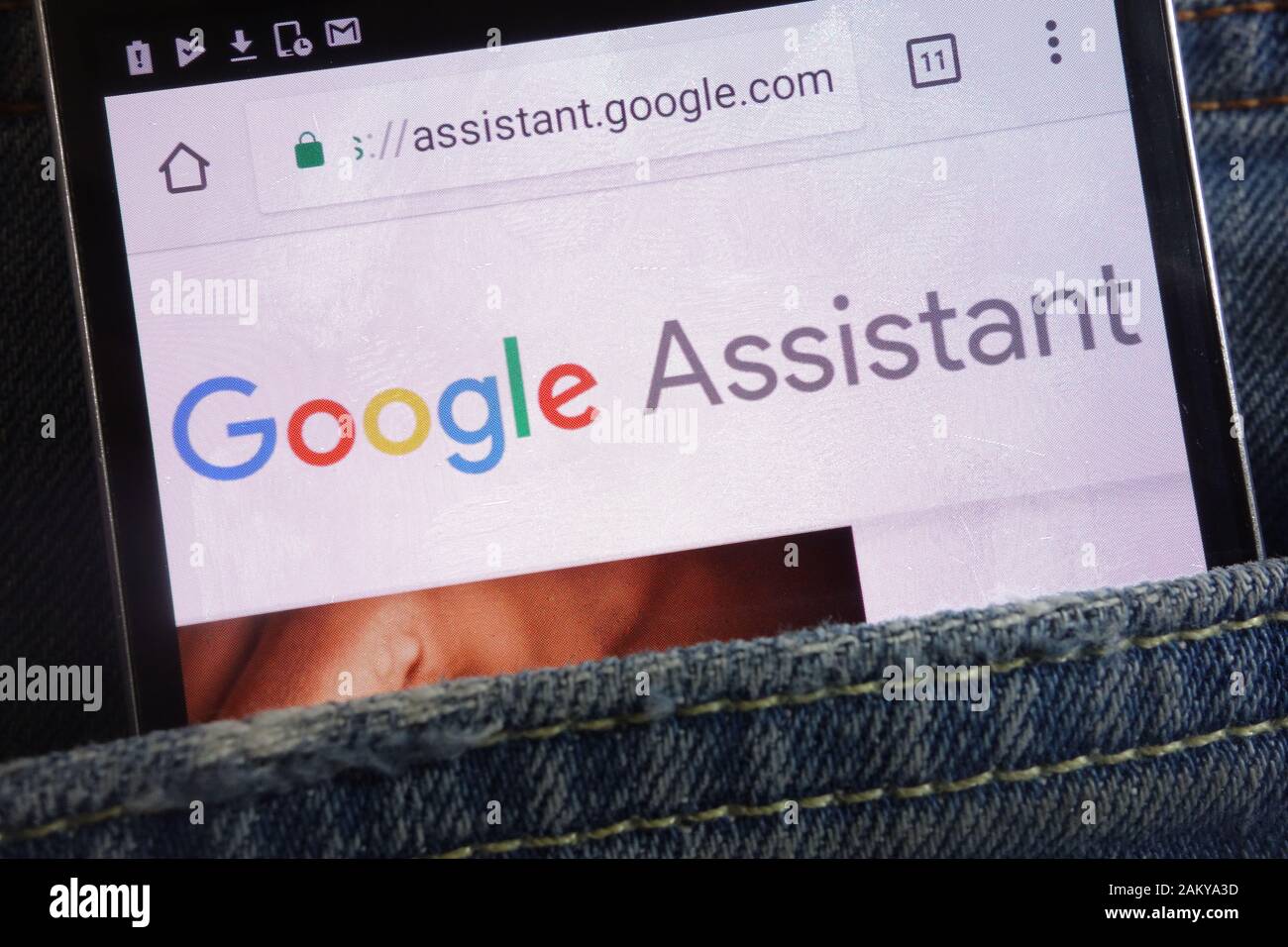 Sito Web Google Assistant visualizzato sullo smartphone nascosto nella tasca dei jeans Foto Stock