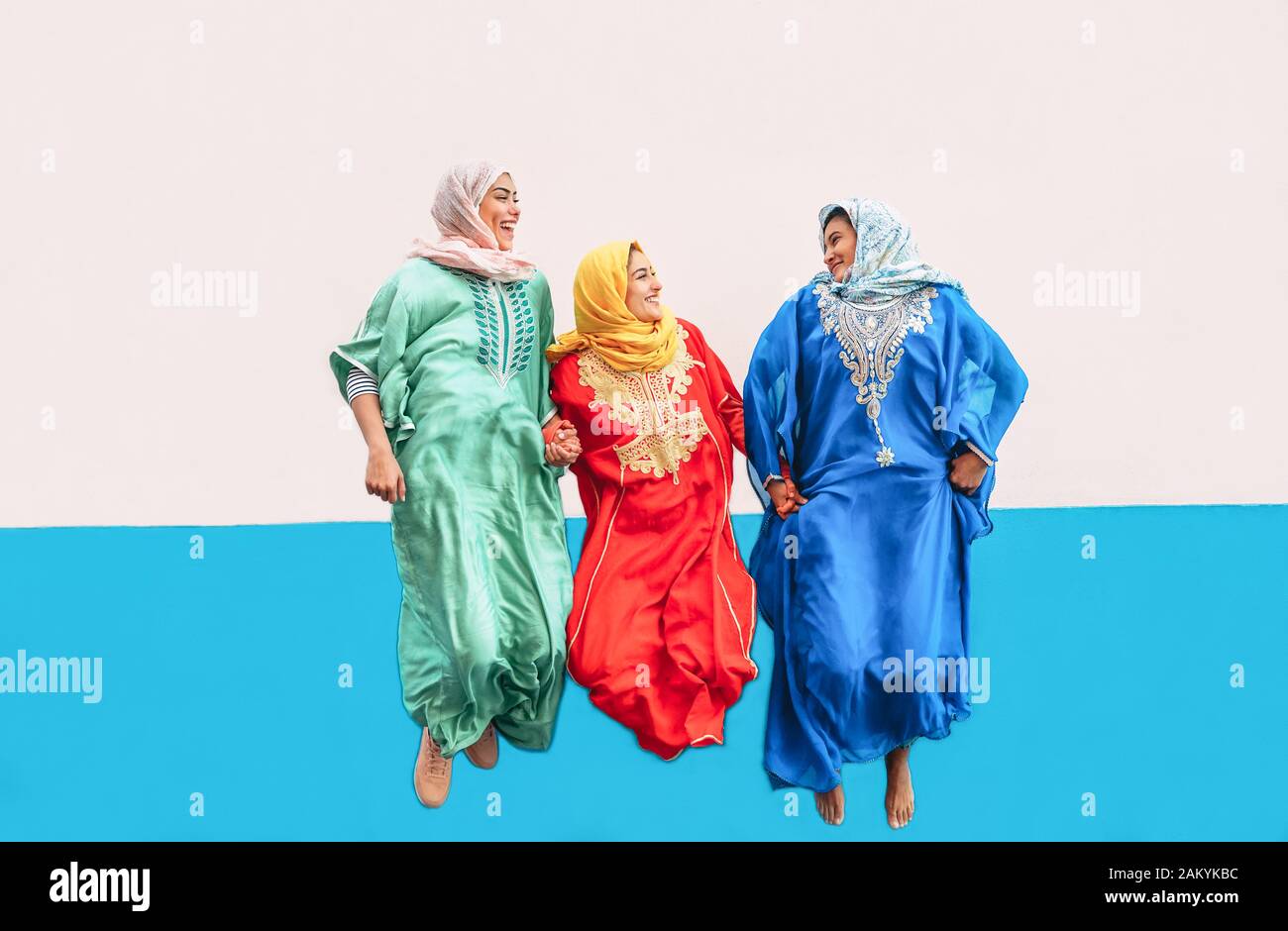 Ragazze musulmane felici che saltano insieme all'aperto - donne arabe che si divertono nel college - concetto di cultura della gente e momenti di stile di vita giovanile Foto Stock