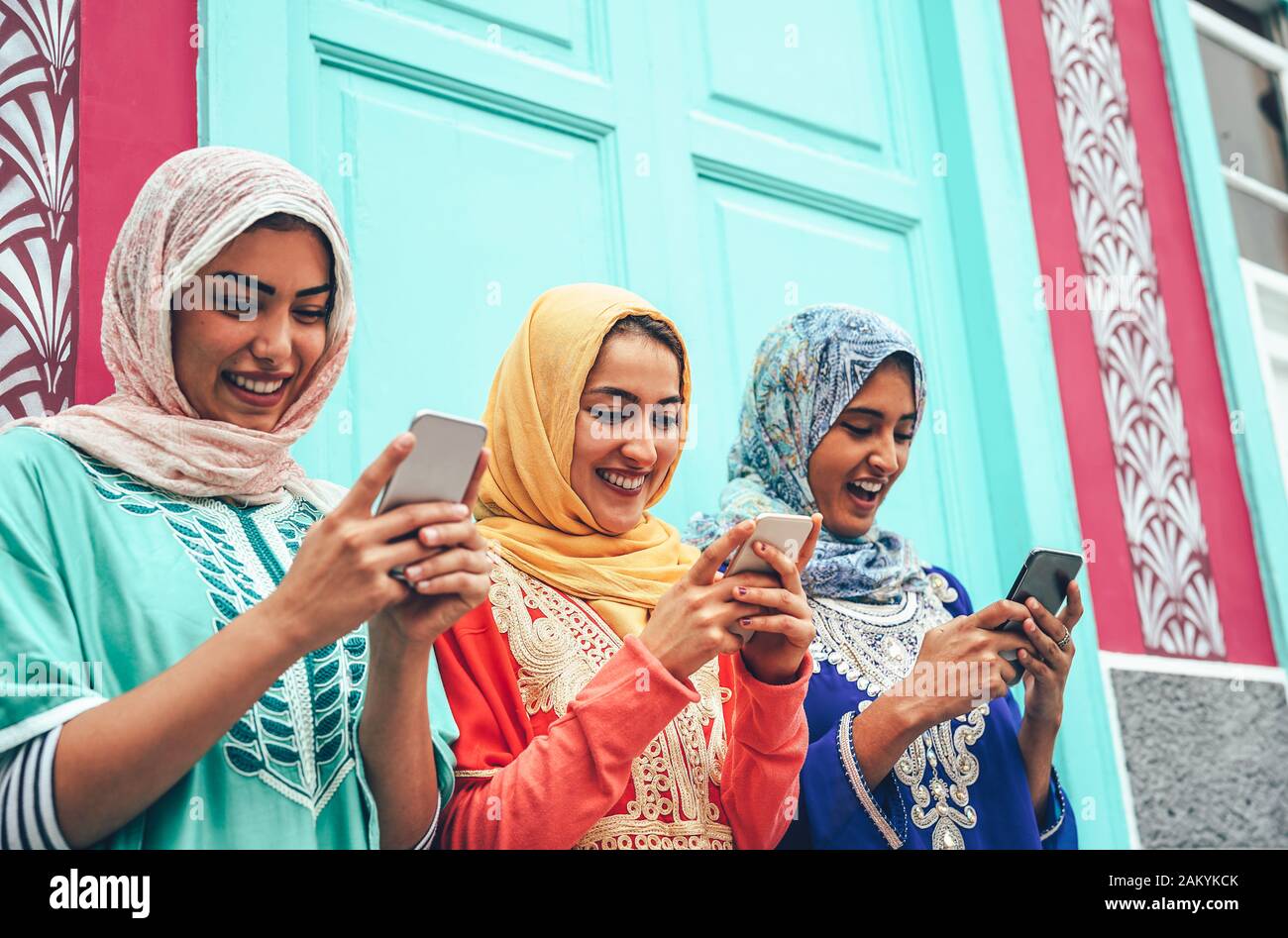 Giovane amico musulmano che usa smartphone mobili nel college - Felici ragazze arabe addicted alla nuova tecnologia app cellulare per i social media Foto Stock