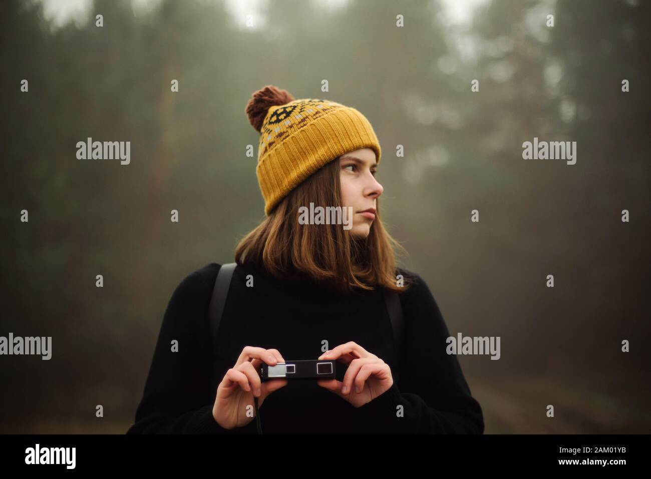Premurosa donna in piedi dalla foresta in foggy meteo Foto Stock