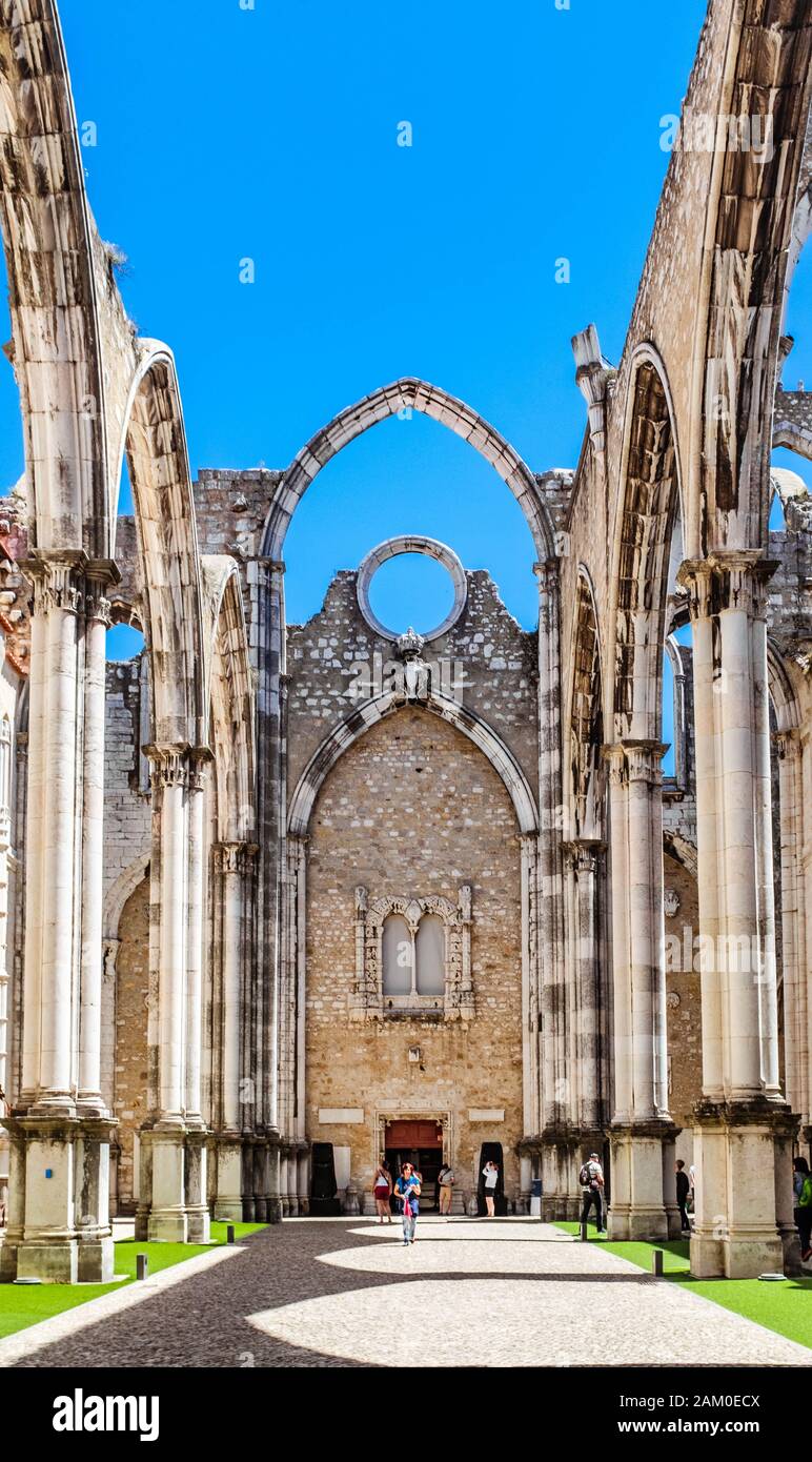 I turisti che esplorano la navata principale rovinata della Chiesa di Carmo in una soleggiata giornata primaverile. Foto Stock