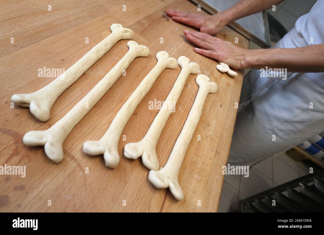 Irsee, Germania. 08 gen, 2020. Gudrun Koneberg, master baker, forme lye dolci in forma di ossa nel panificio del suo panificio. Il panificio si trova vicino al sito in cui le ossa del primate Udo, che sono circa 11,6 milioni di anni, sono stati trovati. (A DPA: 'News dal grande ape Udo - i primati sono ora disponibili come pretzel') Credito: Karl-Josef Hildenbrand/dpa/Alamy Live News Foto Stock