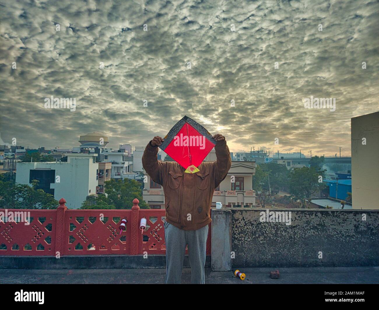 Jaipur, Rajasthan circa 2020 - Fotografia di un uomo che tiene un aquilone sopra la sua testa sul tetto di una casa. La fotografia è scattata in un bellissimo inverno Foto Stock