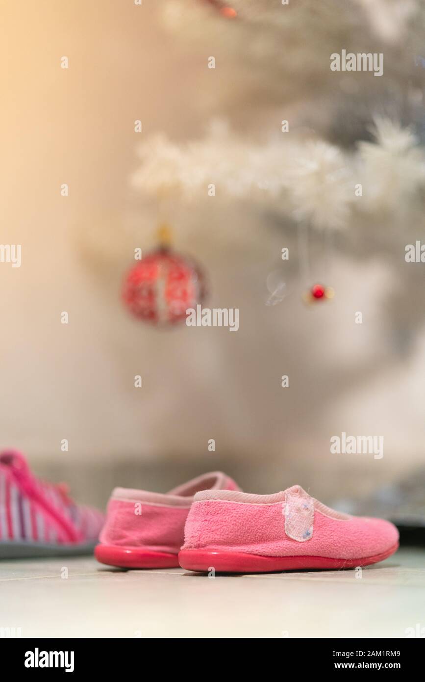 Scarpe da bambina sotto l'albero di Natale per ricevere i regali : Natale francese vigilia tradizione concetto Foto Stock