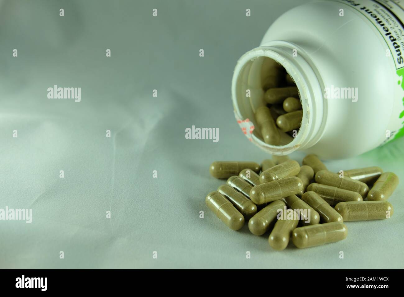 Capsule di supplemento di erbe vicino ad un flacone aperto di pillole; echinacea purpurea. Foto Stock