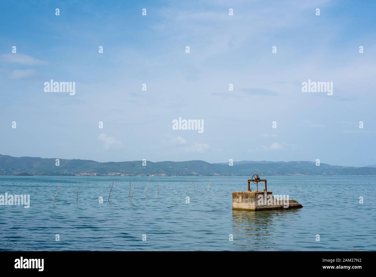 Lago Trasimeno, paesaggio lacustre con molo in cemento visto dalla spiaggia, Italia Foto Stock