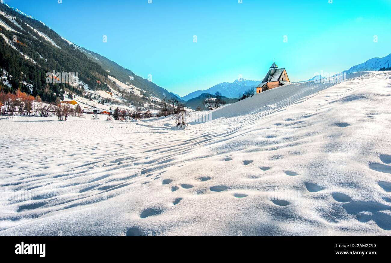 Paesaggio montano, pittoresche impronte di neve nella chiesa panoramica della mattina invernale Foto Stock