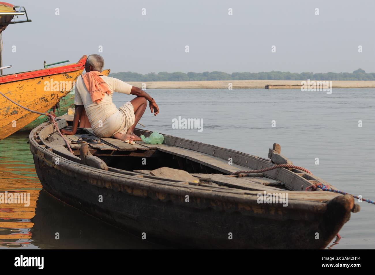 Un vecchio è seduto sulla sua barca Foto Stock