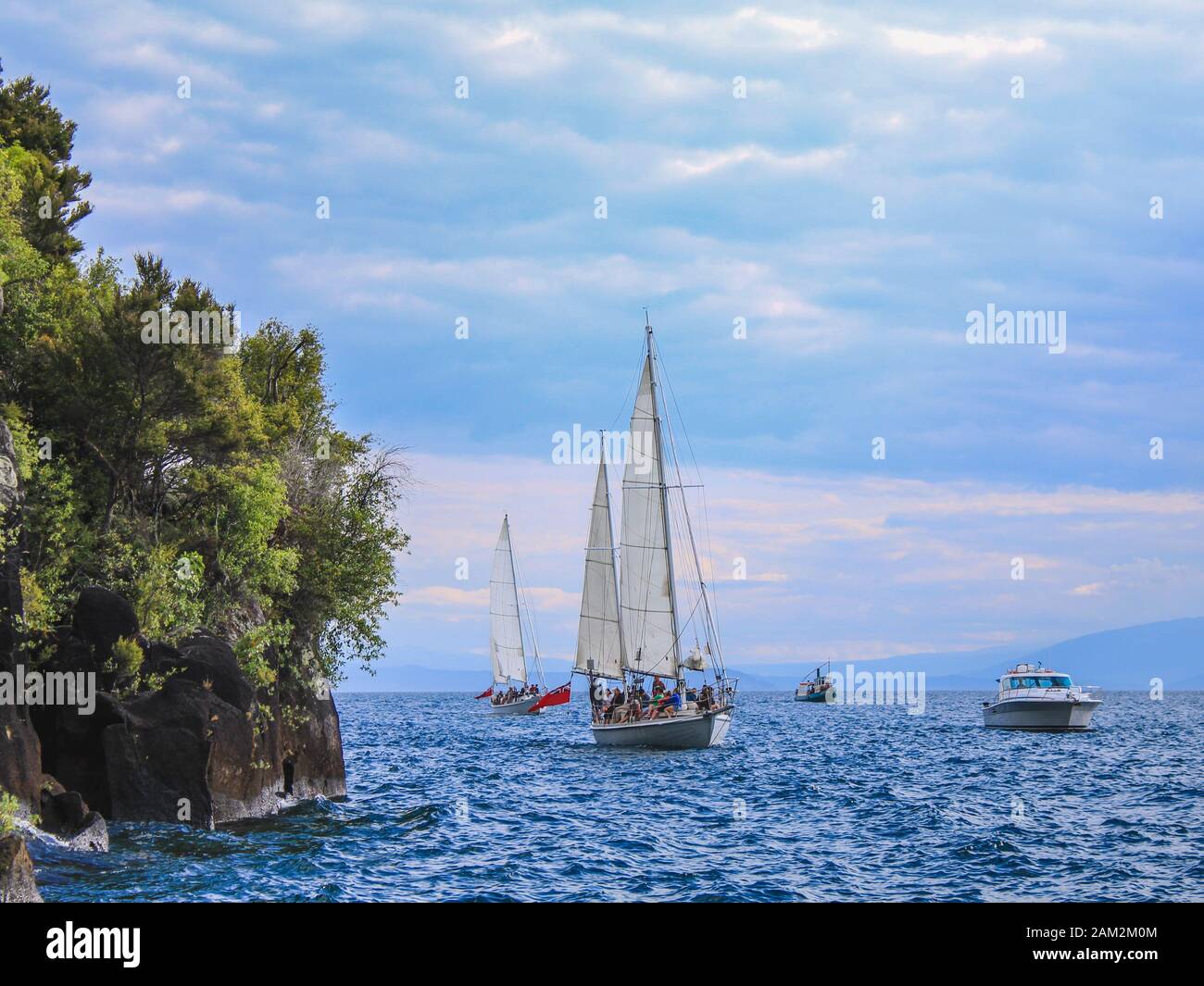 Taupo, Isola del Nord, Nuova Zelanda - Dicembre 26th 2016: I turisti che si avvicinano alle Famose Incisioni rupestri Mine Bay Maori sul Lago Taupo in barca da crociera Foto Stock