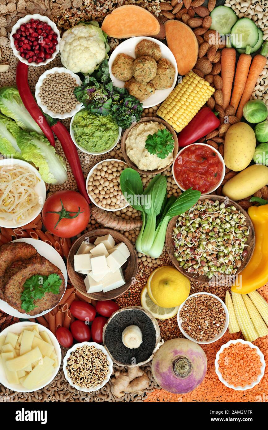 Sana collezione vegana super food con frutta, verdure, noci, spezie, cereali, tofu, falafel e hamburger realizzati con sostituto della carne. Mangiare etico. Foto Stock